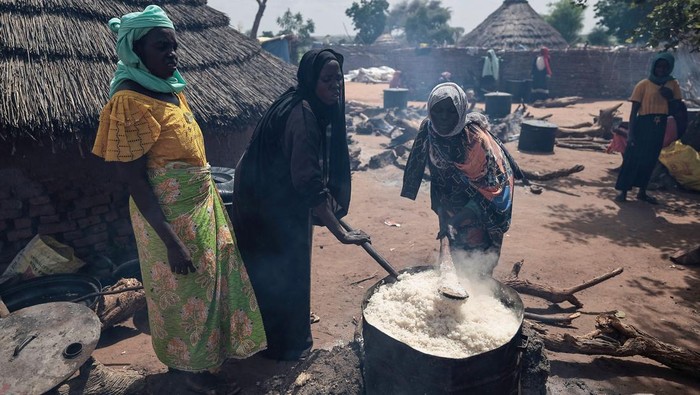 Berbaris Pengungsi Sudan Mengantre Makan Red Cross volunteers cook rice to be distributed to Sudanese people who fled the conflict in Geneina in Sudan's Darfur region, near the refugee camp in Ourang on the outskirts of Adre, Chad July 25, 2023.REUTERS/Zohra Bensemra