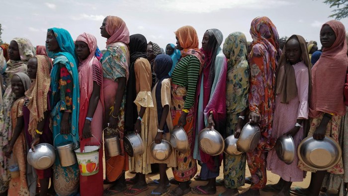 Berbaris Pengungsi Sudan Mengantre Makan Red Cross volunteers cook rice to be distributed to Sudanese people who fled the conflict in Geneina in Sudan's Darfur region, near the refugee camp in Ourang on the outskirts of Adre, Chad July 25, 2023.REUTERS/Zohra Bensemra