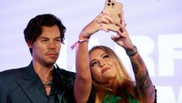 Seorang penggemar berpose dengan patung lilin Harry Styles di museum Madame Tussauds, London, Inggris, Rabu (26/7/2023).  