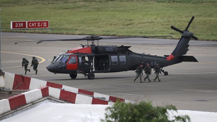 Soldiers run out of the Sikorsky UH-60 Black Hawk helicopter during the annual Han Kuang military exercises that simulates an attack on an airfield at Taoyuan International Airport in Taoyuan, northern Taiwan, Wednesday, July 26, 2023. Taiwan military mobilized for routine defense exercises from July 24-28. (AP Photo/ Chiang Ying-ying)