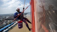 Para pekerja menggunakan standar keselamatan kerja saat bertugas.  