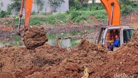 Tampak pekerja dari Dinas Sumber Daya Air Kota Bekasi tengah mengeruk tanah dalam pembanguan waduk, Kamis (27/7/2023).  