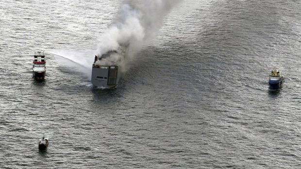 Sebuah kapal memadamkan asap dari kebakaran yang terjadi di sebuah kapal barang di Laut Utara, sekitar 27 kilometer (17 mil) utara pulau Belanda Ameland, Rabu, 26 Juli 2023. Kebakaran di kapal barang Fremantle Highway, yang membawa hampir 3.000 mobil, terbakar di luar kendali pada hari Rabu di Laut Utara, dan penjaga pantai Belanda mengatakan sedang berupaya menyelamatkan kapal agar tidak tenggelam di dekat habitat penting bagi burung migran. (Kustwacht Nederland/Coast Guard Netherlands via AP)