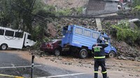 Seorang polisi memeriksa kendaraan yang terkena tanah longsor yang disebabkan oleh Topan Doksuri di Kota Baguio. Doksuri sedikit melemah tetapi tetap berbahaya dengan kecepatan angin 175 kpj (109 mph) dan hembusan hingga 215 kpj (133 mph). Itu bertiup 95 kilometer (59 mil) barat kota pulau Calayan di lepas pantai Cagayan pada Rabu malam, kata peramal cuaca. AP Photo