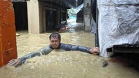Seorang pria melintasi banjir setinggi leher di desanya yang disebabkan oleh Topan Doksuri di kota Laoag, provinsi Ilocos Norte, Filipina utara, Rabu (26/7/2023). Pejabat setempat mengatakan, topan menerbangkan atap rumah, membanjiri desa-desa di dataran rendah dan memicu puluhan tanah longsor. AP/Bernie Sipin Dela Cruz