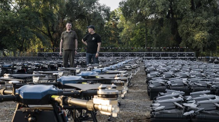 Mykhailo Fedorov, Ukrainian minister of digital transformation, right, and Yuriy Shchygol, head of State Special Communications Service, pose for a photo next to 1700 drones that are being sent to the frontline to be used against Russian forces, in Kyiv, Ukraine, Tuesday, July 25, 2023. (AP Photo/Libkos)