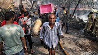 Beberapa warga mencoba menyelamatkan barang-barang yang tersisa.