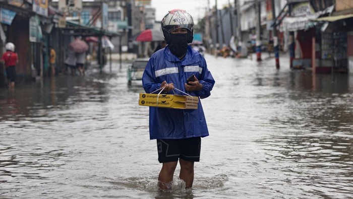 Filipina Banjir Bandang Diterjang Topan Doksuri Commuters wade through a flooded street in the aftermath of typhoon Doksuri, in Valenzuela, Metro Manila, Philippines July 27, 2023. REUTERS/Eloisa Lopez