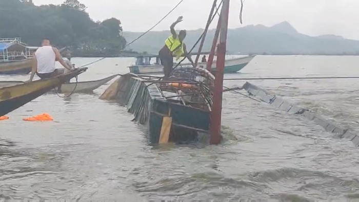 A man stands on the capsized passenger boat in Binangonan, Rizal province, Philippines, July 27, 2023 in this screen grab taken from a video by Philippine Coast Guard/Handout via REUTERS  THIS IMAGE HAS BEEN SUPPLIED BY A THIRD PARTY. NO RESALES. NO ARCHIVES