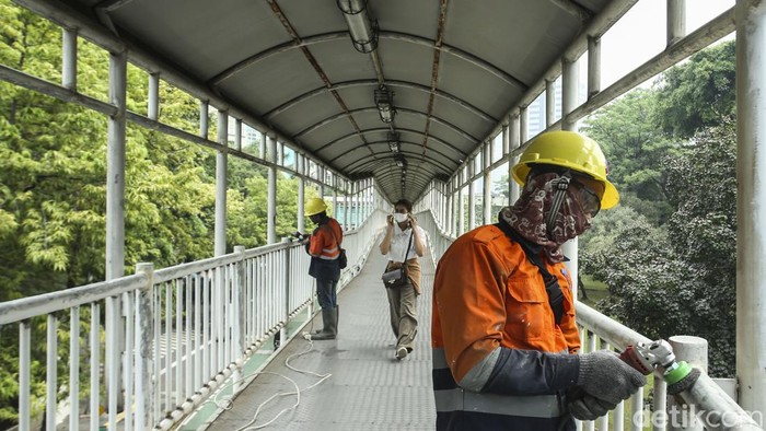 JPO Halte TransJakarta Bendungan Hilir Dicat Ulang Biar Lebih Kinclong Pekerja menyelesaikan peremajaan halte TransJakarta di halte Bendungan Hilir, Jakarta, Jumat (28/7/2023).