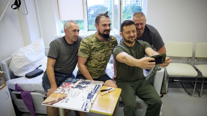 Momen Zelensky Jenguk dan Foto Bareng Tentaranya di Rumah Sakit Presiden Ukraina Volodymyr Zelensky menjenguk tentaranya yang terluka di rumah sakit militer di Odesa, Kamis (27/7/2023) waktu setempat. Zelensky juga sempat foto bersama dengan tentara yang menjalani perawatan.