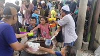 Panitia pun meletakkan bubur yang telah dimasak dengan bubur putih ditambah irisan telur dadar, ikan teri, kerupuk dan bawang merah ke dalam wadah yang dibawa warga.