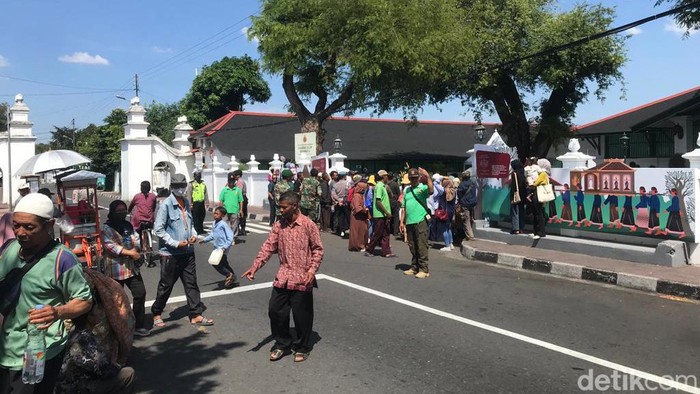 Warga antre masuk ke Museum Wahanarata Jogja untuk mengambil air sisa jamasan kereta kencan, Jumat (28/7/2023).