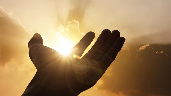 Hand on sunset background success, peace,freedom concept