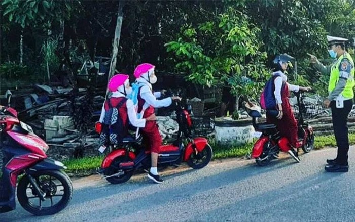 Anak kecil naik sepeda listrik.