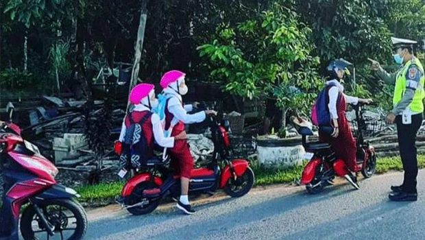 Anak kecil naik sepeda listrik.