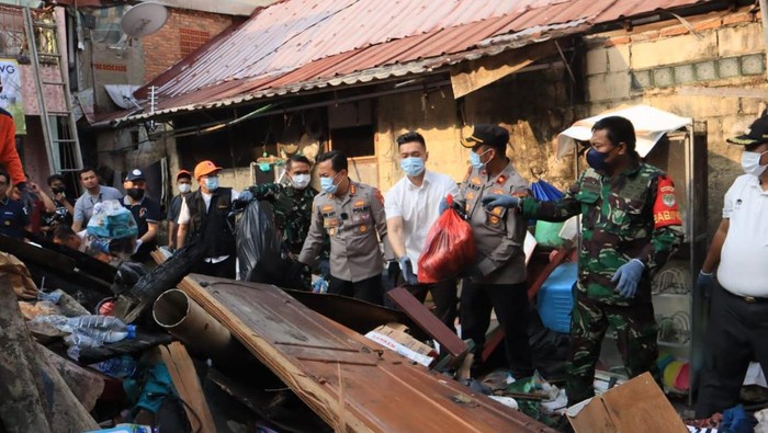 Polisi dan TNI bahu-membahu membersihkan puing-puing kebakaran di Setiabudi, Jakarta Selatan.
