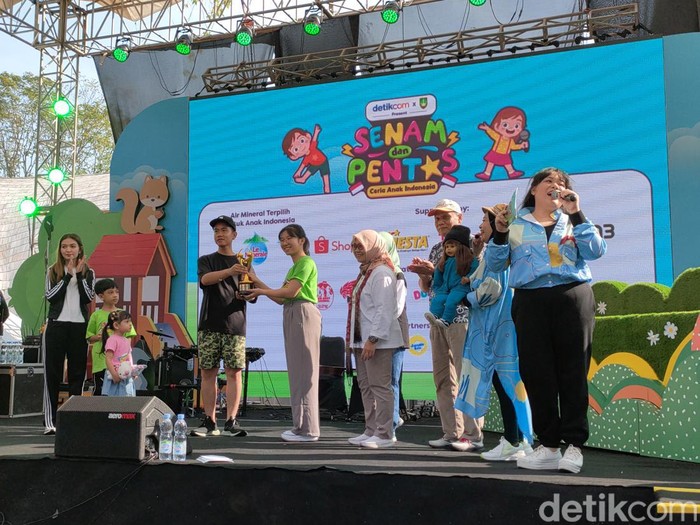 Wali Kota Solo Gibran Rakabuming Raka menyerahkan penghargaan Kota Layak Anak ke perwakilan forum anak di sela acara Senam dan Pentas Ceria Anak Indonesia di Solo Safari, Sabtu (29/7/2023) pagi.