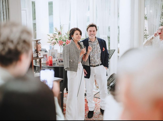 Farah Quinn sendiri tampil kasual dengan jaket tweed abu-abu dan celana putih. Kalung mutiara dari Chanel menambah kesan elegan dari penampilannya. Sementara Charles mengenakan kemeja bermotif dan jas serta dilengkapi dengn celana putih.  Foto: Dok. Instagram/@farahquinnofficial