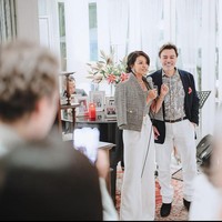 Farah Quinn sendiri tampil kasual dengan jaket tweed abu-abu dan celana putih. Kalung mutiara dari Chanel menambah kesan elegan dari penampilannya. Sementara Charles mengenakan kemeja bermotif dan jas serta dilengkapi dengn celana putih.  Foto: Dok. Instagram/@farahquinnofficial