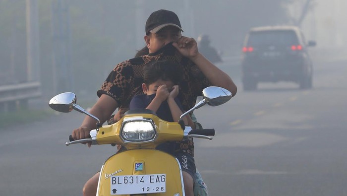 Kabut asap dampak karhutla di Aceh Barat Sejumlah pengendara melintasi jalan yang berselimut kabut asap kebakaran hutan dan lahan (karhutla) di jalan lintas nasional Medan-Banda Aceh Desa Suak Raya, Johan Pahlawan, Aceh Barat, Aceh, Sabtu (29/7/2023). Menurut pantauan Badan Meteorologi Klimatologi dan Geofisika (BMKG) Stasiun Meteorologi Kabupaten Nagan Raya melalui satelit NASA/MODIS terdapat dua titik api (hotspot) di kabupaten itu dengan suhu udara mencapai 31 celsius pada siang hari dengan kecepatan angin 3 knots/jam yang rata-rata bertiup dari arah timur laut, BMKG juga menghimbau masyarakat dan pengguna jalan lintas mengenakan masker medis apabila keluar rumah dan berhati-hati karena kabut asap berdampak pada minimnya jarak pandang. ANTARA FOTO/Syifa Yulinnas/rwa.