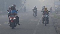Sejumlah pengendara melintasi jalan yang berselimut kabut asap kebakaran hutan dan lahan (karhutla) di jalan lintas nasional Medan-Banda Aceh Desa Suak Raya, Johan Pahlawan, Aceh Barat, Aceh, Sabtu (29/7/2023).