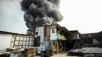 Asap juga mengepul dari permukiman warga yang terbakar.