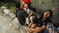 Warga tak kuasa menahan tangis saat rumahnya ludes terbakar. 