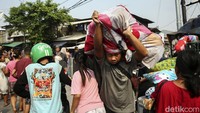 Warga yang menjadi korban kebakaran lalu lalang menyelamatkan harta bendanya. 