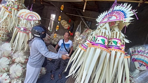 Seorang warga membeli kelengkapan penjor di kios milik Ayu Ningrat di lingkungan Banjar Delod Rurung, Desa Delod Peken, Tabanan, Bali, Minggu (30/7/2023).