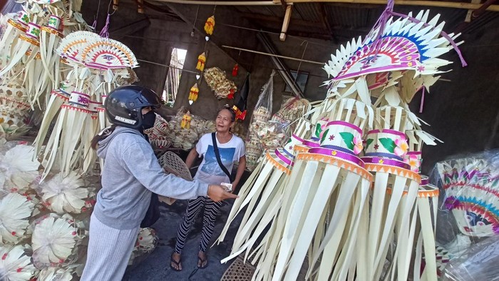 Seorang warga membeli kelengkapan penjor di kios milik Ayu Ningrat di lingkungan Banjar Delod Rurung, Desa Delod Peken, Tabanan, Bali, Minggu (30/7/2023).