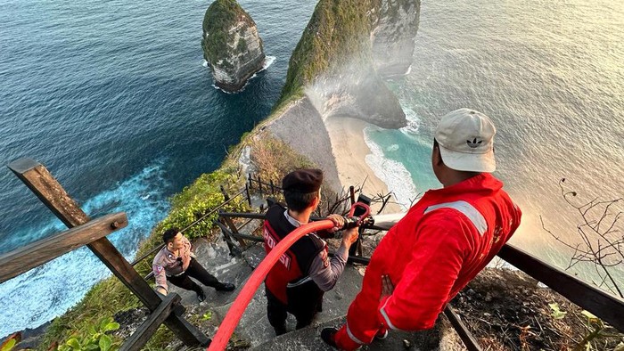 Upaya pemadaman kebakaran di Pantai Kelingking, Nusa Penida, Minggu (30/7/2023). (Dok Polsek Nusa Penida)