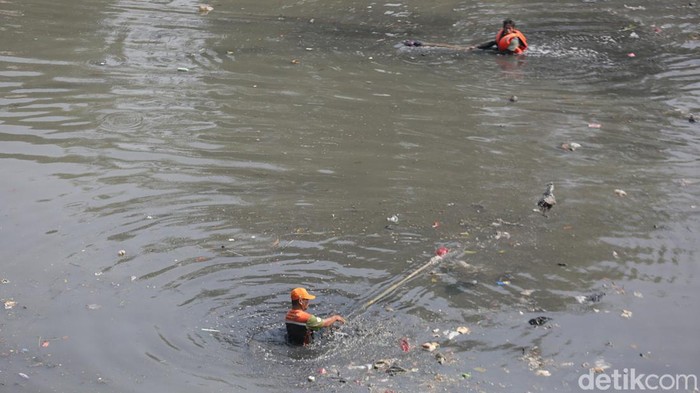 Petugas PPSU membersihkan sampah yang ada dialiran Banjir Kanal Timur di Cipinang Besar Selatan, Jakarta Timur. Senin (31/7/2023). Tampak mereka mengunakan pelampung dalam membersihkan sampah yang ada di aliran banjir kanal timur.