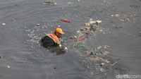 Petugas Unit Pengelola Sampah Badan Air (UPS BA) Dinas Lingkungan Hidup DKI Jakarta membersihkan sampah yang ada di aliran Banjir Kanal Timur di Cipinang Besar Selatan, Jakarta Timur. Senin (31/7/2023).