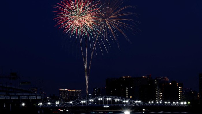 People watch fireworks celebrating the summer season at Sumidagawa fireworks festival in Tokyo, Japan, July 29, 2023. The fireworks festival returned for the first time in four years following the lift of COVID-19 restrictions.   REUTERS/Kim Kyung-Hoon