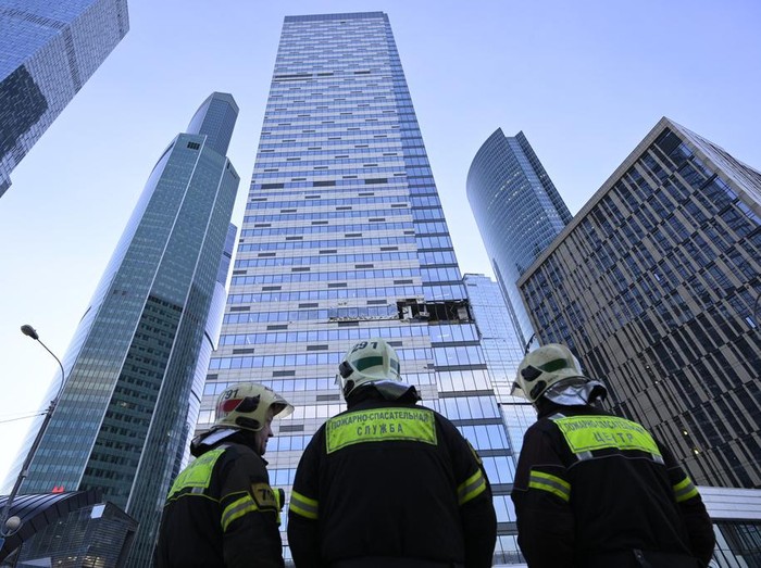 Investigators examine a damaged skyscraper in the 
