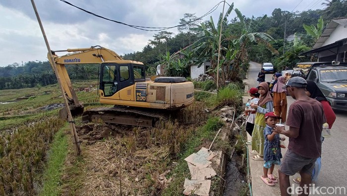 Ekskavator yang disiagakan oleh tim pencari gabungan untuk membantu membendung aliran sungai dalam operasi pencarian delapan penambang terjebak di Desa Pancurendang, Kecamatan Ajibarang, Banyumas, Senin (31/7/2023).