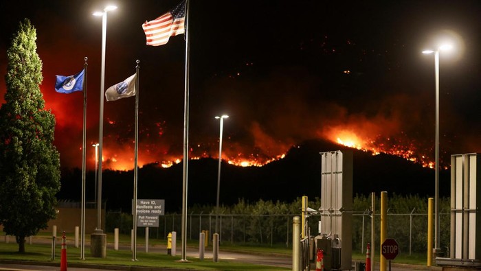 A long exposure image shows the Eagle Bluffs Wildfire, which crossed the border from the U.S. state of Washington, and prompted evacuation orders in Osoyoos, British Columbia, Canada July 30, 2023. REUTERS/Jesse Winter