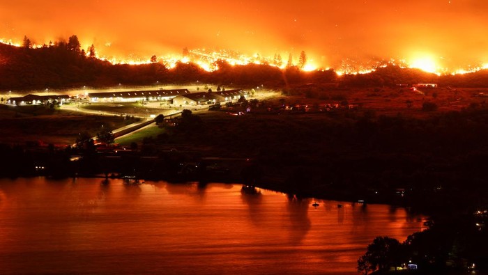 Kebakaran Hutan Membara di Perbatasan AS-Kanada A long exposure image shows the Eagle Bluffs Wildfire, which crossed the border from the U.S. state of Washington, and prompted evacuation orders in Osoyoos, British Columbia, Canada July 30, 2023. REUTERS/Jesse Winter