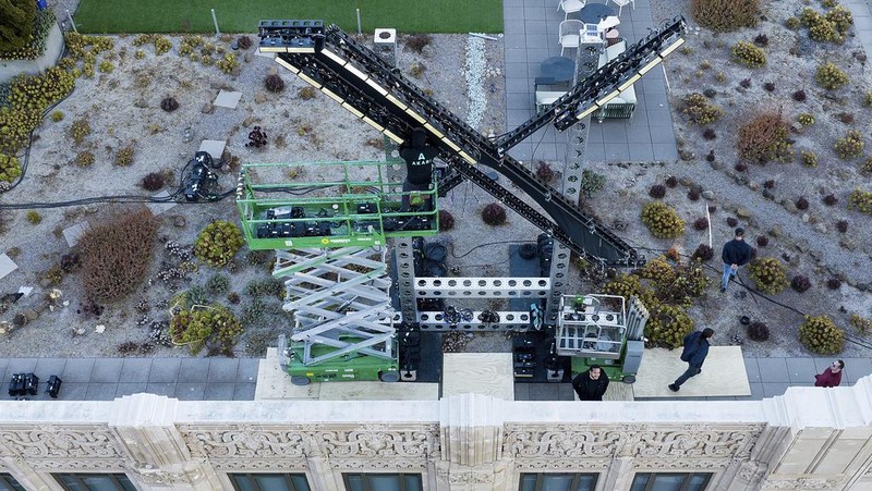 Workers install lighting on an 