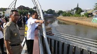 Jokowi didampingi Pj Gubernur DKI Jakarta Heru Budi Hartono (kiri) melihat aliran sungai usai meresmikan sodetan Kali Ciliwung. Menurut Jokowi dengan adanya sodetan Ciliwung paling tidak 6 kelurahan di Jakarta tidak akan merasakan banjir lagi. ANTARA FOTO/Akbar Nugroho Gumay