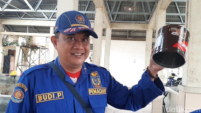 Petugas damkar saat menunjukkan kaleng biskuit yang jepit kepala balita