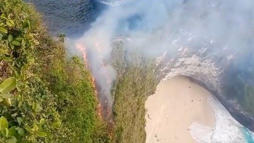 Semak belukar di Pantai Kelingking, Desa Bungamekar, Nusa Penida, Klungkung, Bali, terbakar pada Minggu sore (30/7/2023).