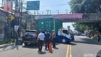 Satlantas Polresta Bogpr Kota mengevakuasi truk kontainer tersangkut di jembatan talang Jl KS Tubun Kedunghalang Kota Bogor. Arus lalu lintas (lalin) di sekitar lokasi ditutup sementara. (M Sholihin/detikcom)