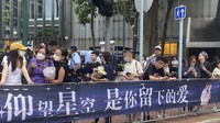 Penggemar penyanyi dan penulis lagu Coco Lee, yang dikenal untuk suaranya yang kuat dan penampilan live, berkumpul dengan bunga untuk memberi penghormatan pada pemakamannya di Hong Kong. AP/Annie Cheung  