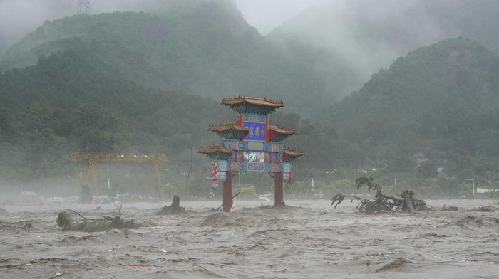 A traditional gate is seen inundated by flood waters in the Miaofengshan area on the outskirts of Beijing, Tuesday, Aug. 1, 2023. Chinese state media report some have died and others are missing amid flooding in the mountains surrounding the capital Beijing. (AP Photo/Ng Han Guan)