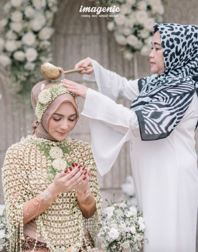Ini potret Citra Kirana yang melakukan sesi siraman dengan adat Sunda sebelum menikah dengan Rezky Aditya pada 2019. Ia memilih hijab warna krem yang cerah. Foto: dok. Imagenic