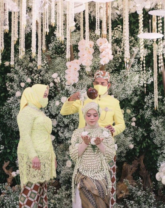 Lesty Kejora menjalani proses siraman adat Sunda sebelum menikah dengan Rizky Billar. Ia juga mengenakan hijab krem senada dengan kainnya. Foto: Instagram @riomotret