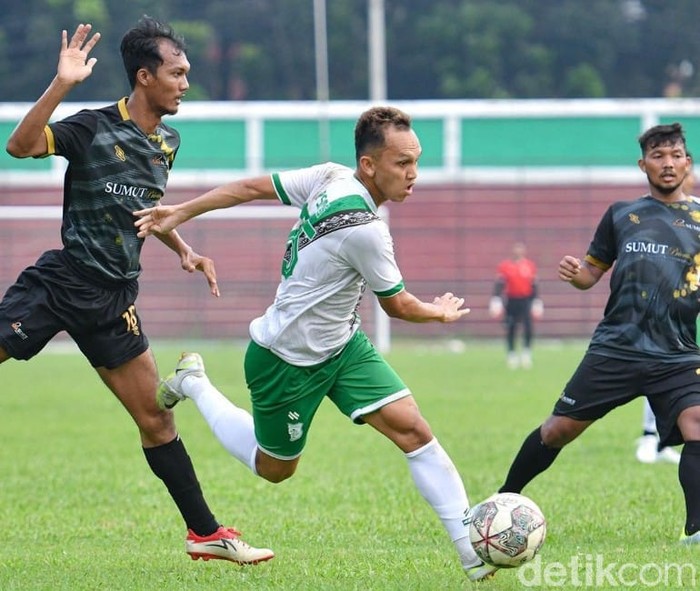 Pemain PSMS Medan, Rachmad Hidayat saat melewati pemain PS Bank Sumut di Stadion Teladan, Medan.