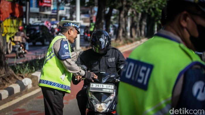 Polisi menilang penerobos jalur TransJakarta di Arteri Pondok Indah, Jakarta. Penilangan dilakukan untuk menertibkan pengendara bandel.